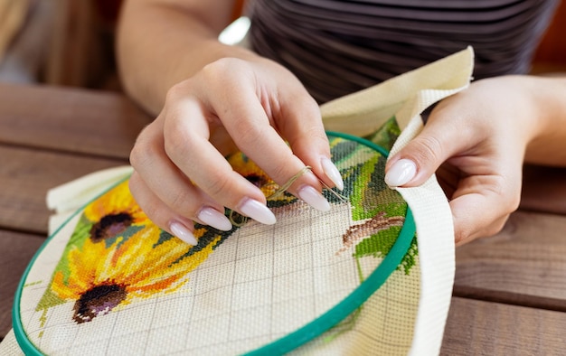 detail ruky pri vyšívaní s ihlou a niťou